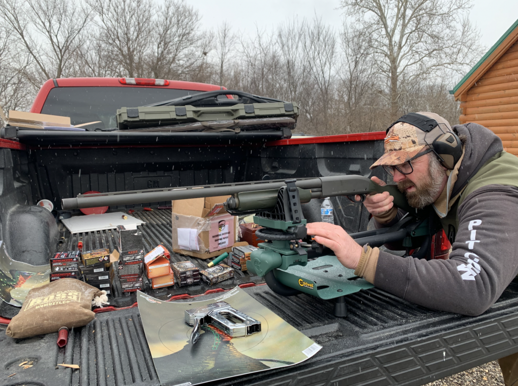 A man shooting from the back of a red truck