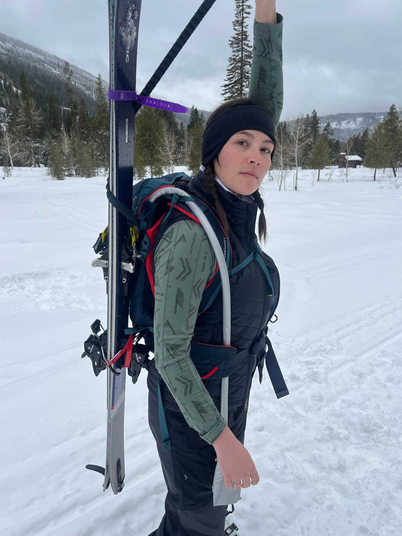 Pull the lanyard behind your head to fix skis vertically against the side of the bag.