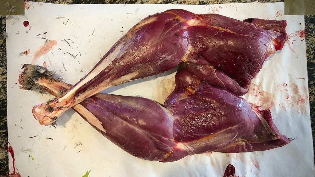 Wild turkey drumstick and thighs on a cutting board.