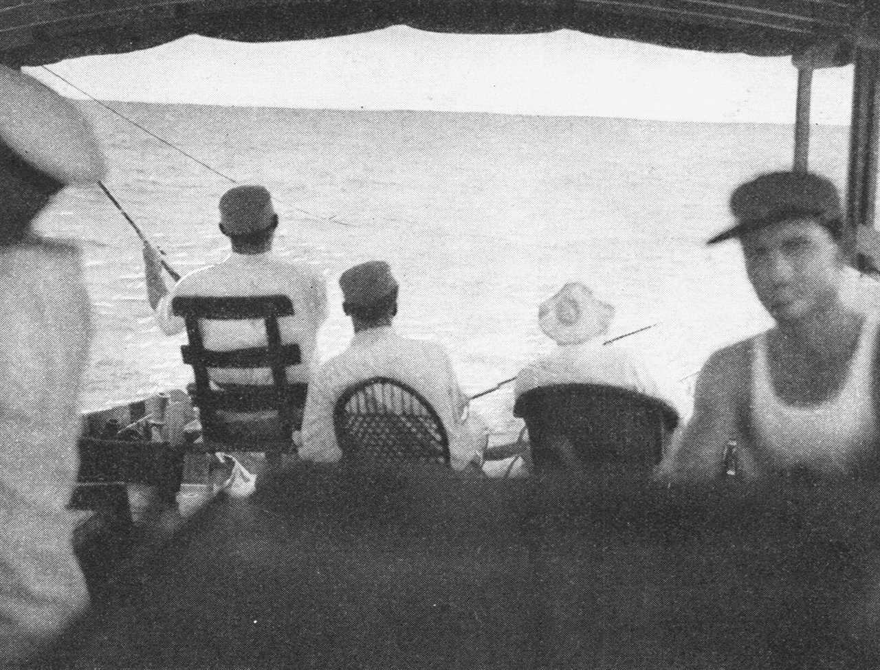 old magazine photograph of ernest hemingway fishing from the back of a boat