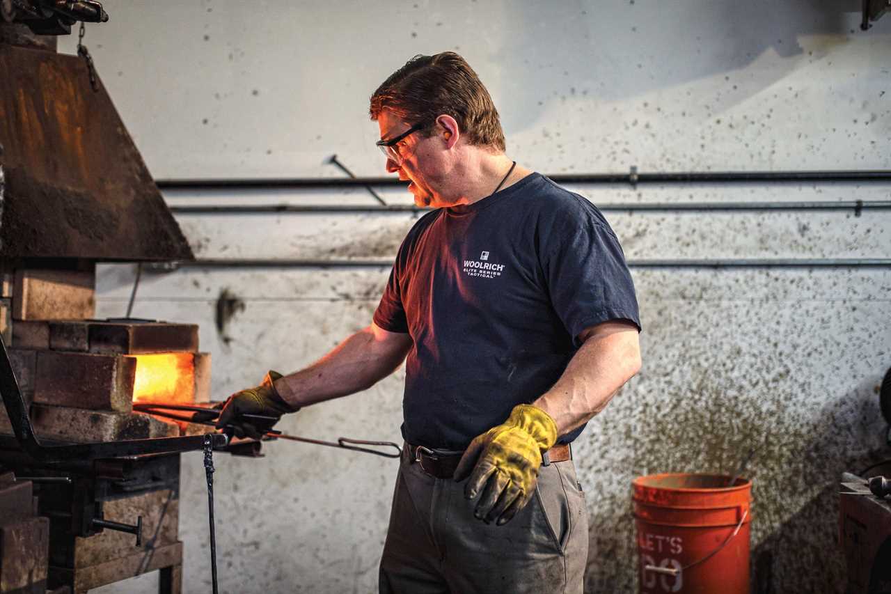 A knifemaker heats a blade.