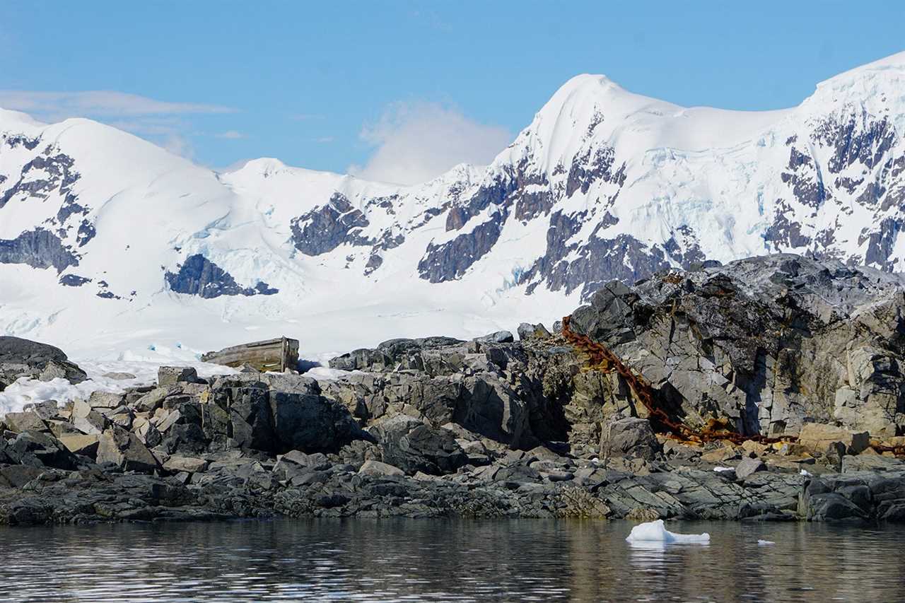 a wooden boat sits atop a snowy rock outcropping