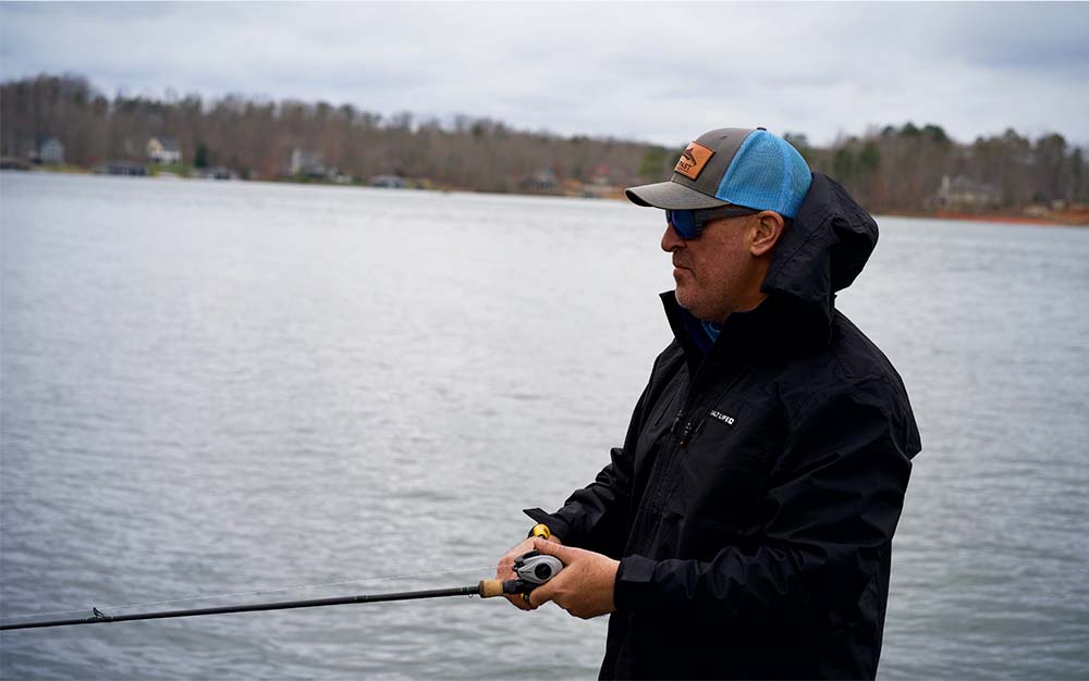 A man on a river holding a fishing rod