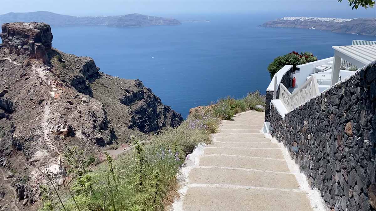 Conctrete steps down a coastal path - the Fira to Oia Hike - with an endless ocean in the background