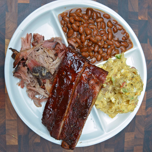 BBQ plate with pork, spare ribs, potato salad and BBQ beans