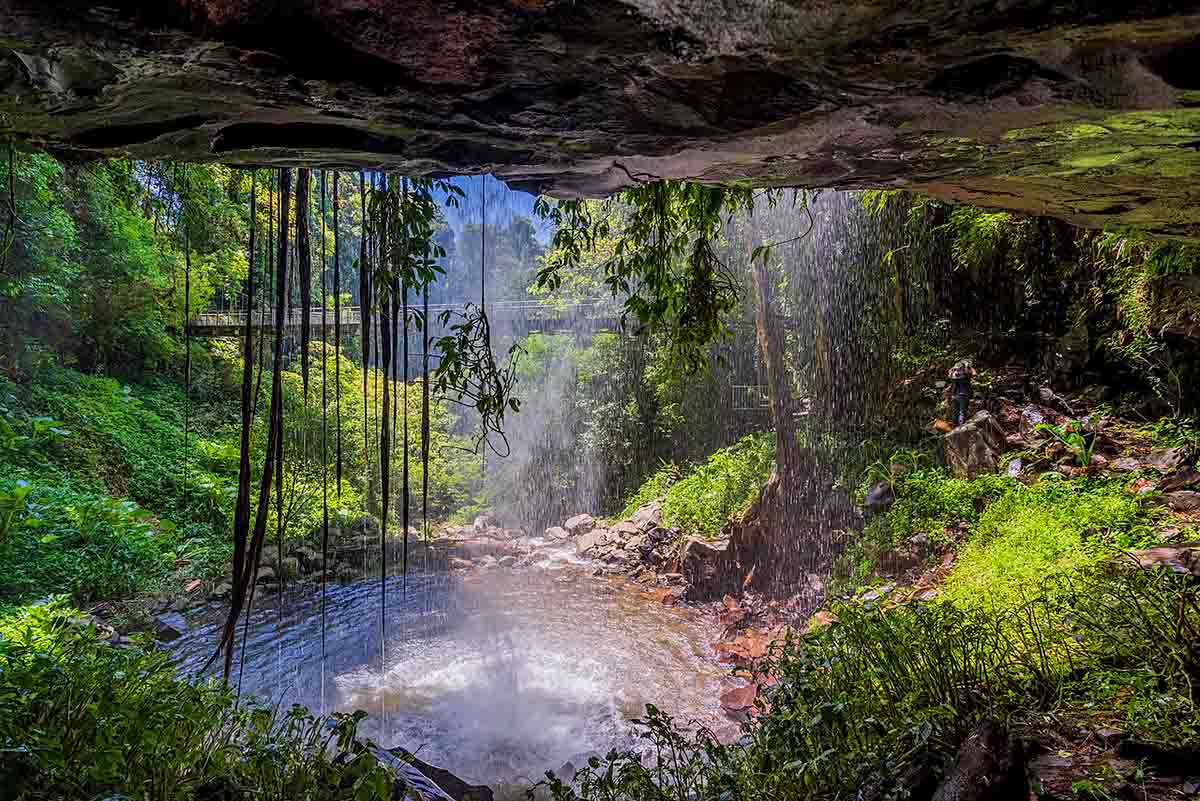 Looking out from a cave, through the misty veil of Crystal Shower Falls. There's a suspension bridge across the gorge.