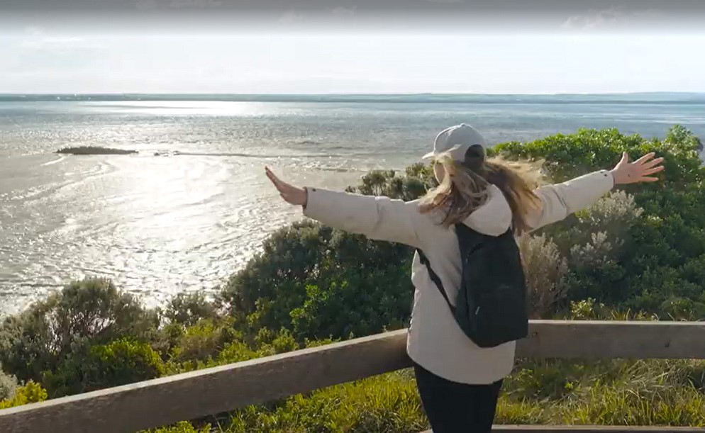 Julia Zemiro stands, arms outstretched, looking out at the ocean from Point Nepean