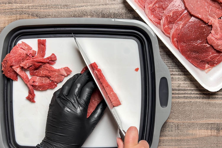 slicing raw beef for jerky