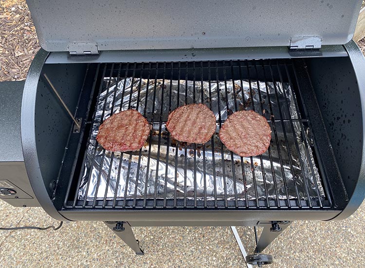 burger patties grilling on traeger tailgater