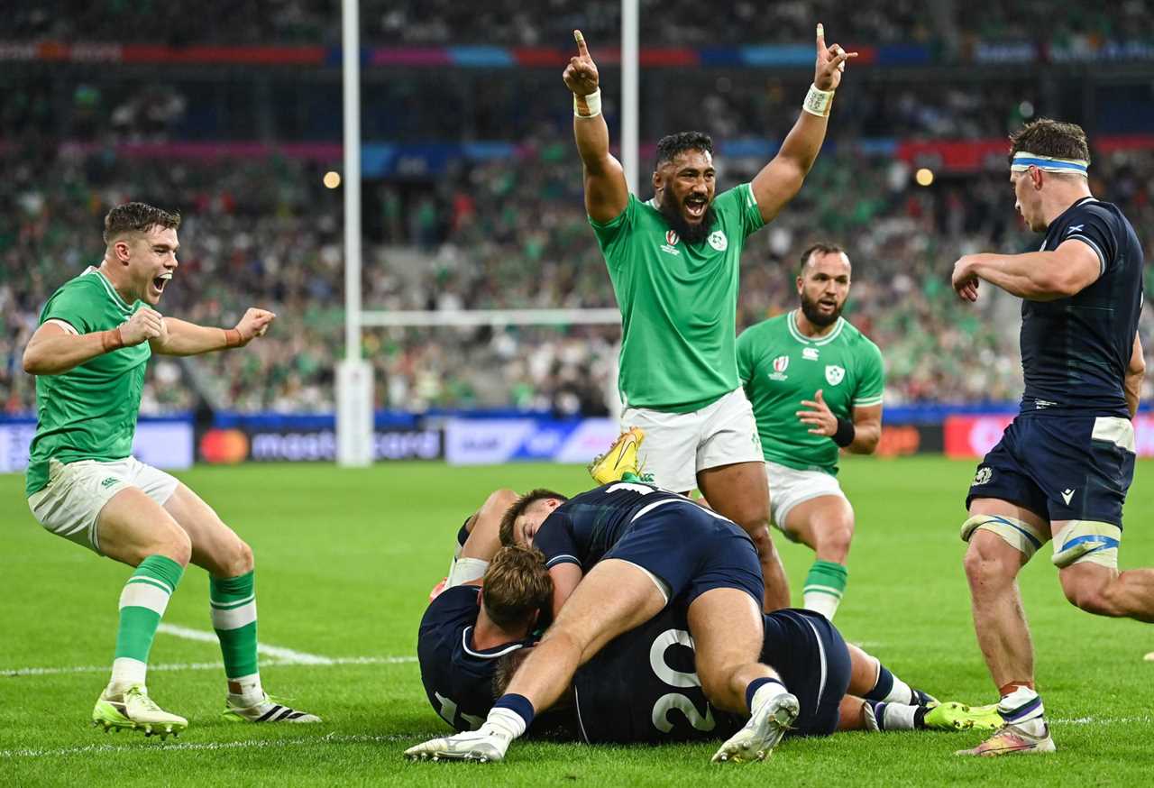 Hugo Keenan of Ireland, hidden, scores his side's fourth try, despite the efforts of Scotland's Duhan van der Merwe, left, and Matt Fagerson, as teammates Garry Ringrose, left, and Bundee Aki celebrate, during the 2023 Rugby World Cup Pool B match between Ireland and Scotland at the Stade de France in Paris, France. (Photo By Ramsey Cardy/Sportsfile via Getty Images)