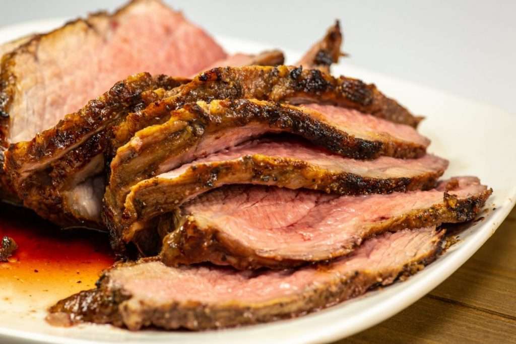 Cooked coffee marinated Tri-tip roast, sliced and on a platter.
