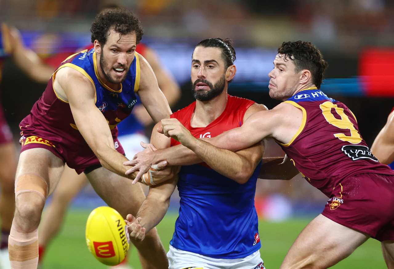 Brodie Grundy of the Demons handballs.