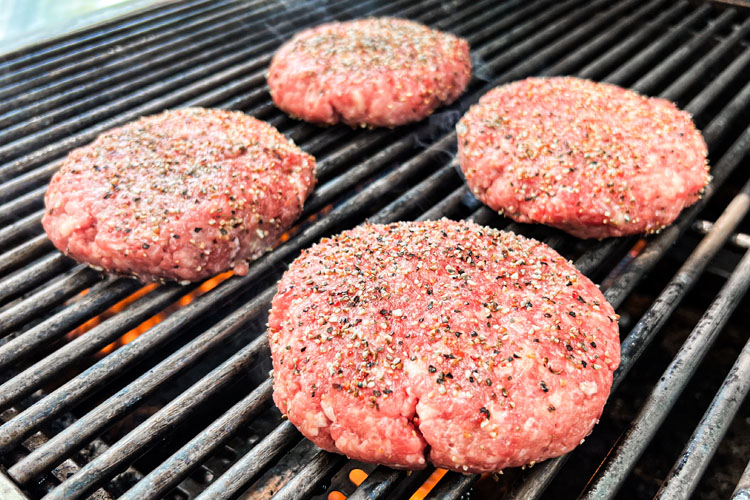 raw tri tip burger patties on the grill