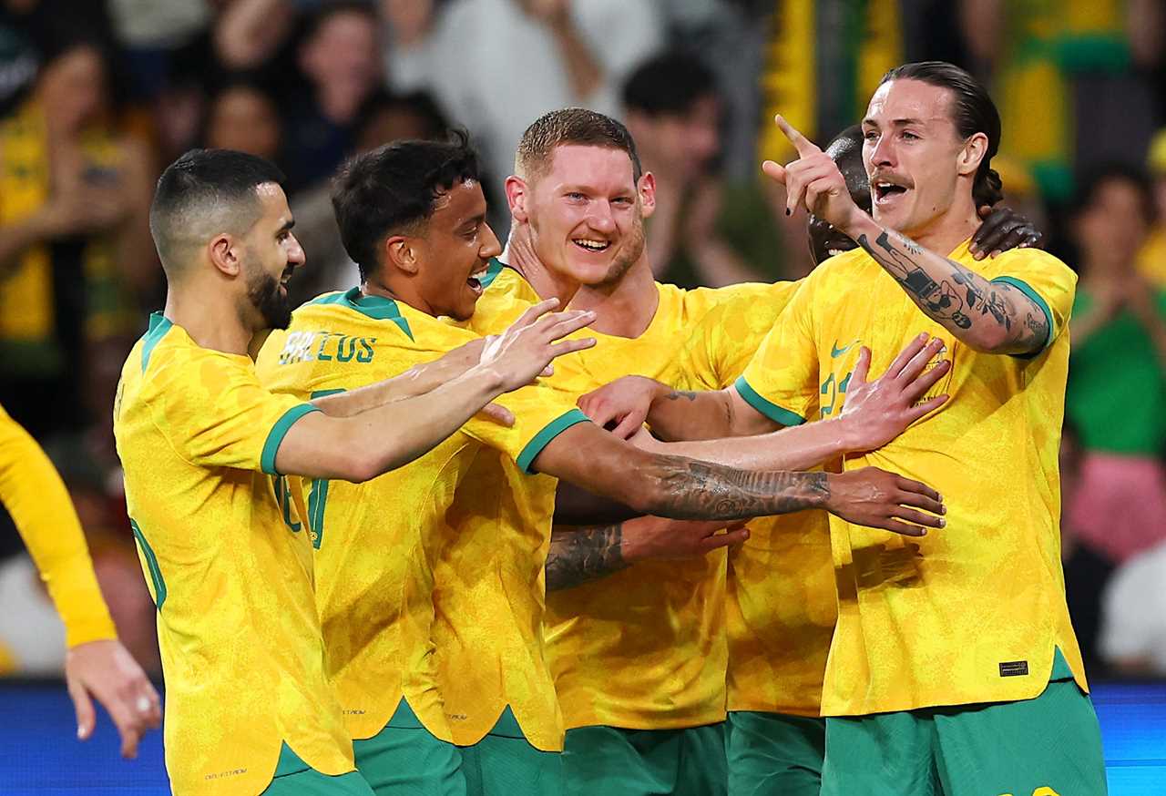 Jackson Irvine celebrates a goal with Socceroos teammates