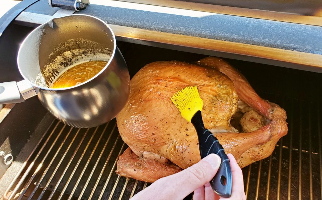 Basting a turkey with brush and basting sauce