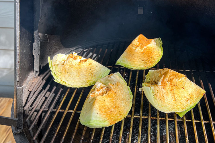 raw seasoned cabbage on the smoker