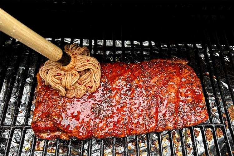 western carolina ribs in the smoker being mopped