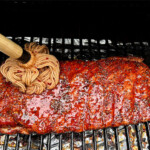 western carolina ribs in the smoker being mopped