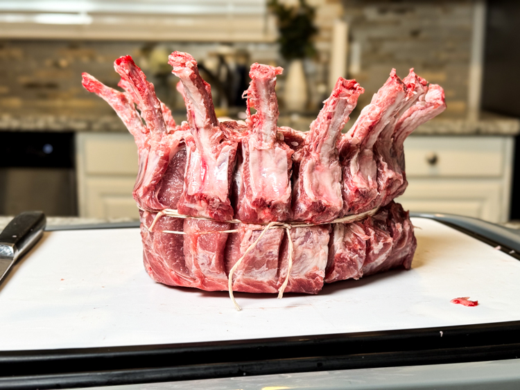 a raw crown of pork on a white board