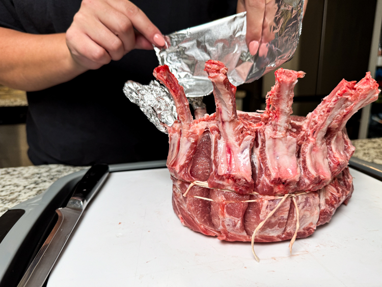 hands placing foil around bones