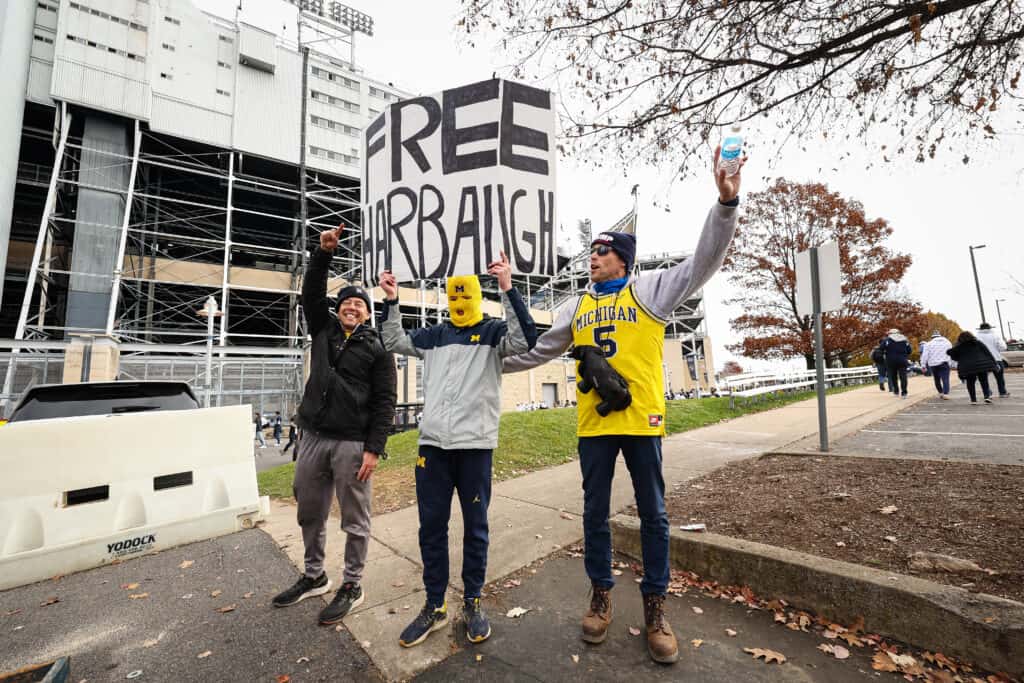 Michigan Wolverines fans hold a sign after the suspension of head coach Jim Harbaugh of the Michigan Wolverines is announced before the game against the Penn State Nittany Lions Beaver Stadium on November 11, 2023 in State College, Pennsylvania.