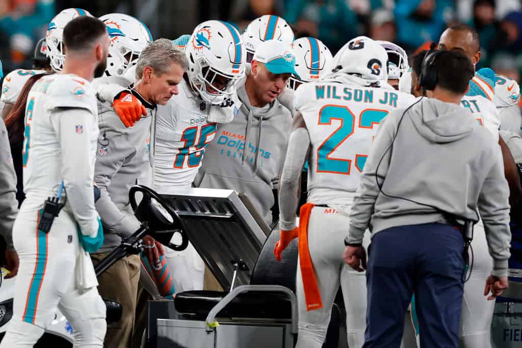 Jaelan Phillips #15 of the Miami Dolphins is helped onto a cart after being injured in a play against the New York Jets during the fourth quarter in the game at MetLife Stadium on November 24, 2023 in East Rutherford, New Jersey.
