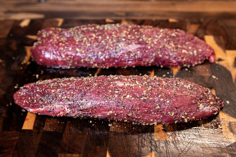 raw seasoned teres major on a wooden chopping board