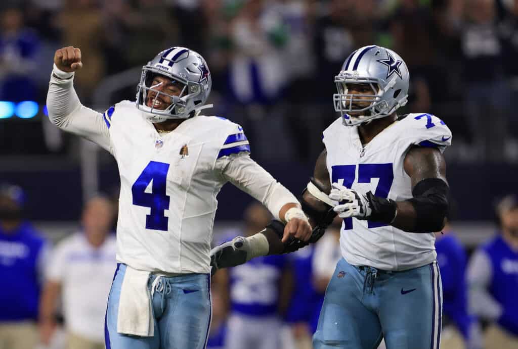 ARLINGTON, TEXAS - NOVEMBER 30: Quarterback Dak Prescott #4 of the Dallas Cowboys celebrates with offensive tackle Tyron Smith #77 after throwing for a touchdown during the 4th quarter of the game against the Seattle Seahawks at AT&T Stadium on November 30, 2023 in Arlington, Texas.