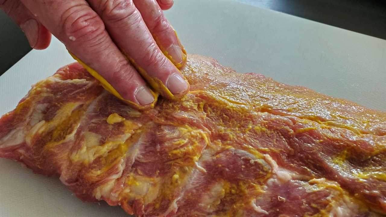 Applying mustard binder to baby back ribs