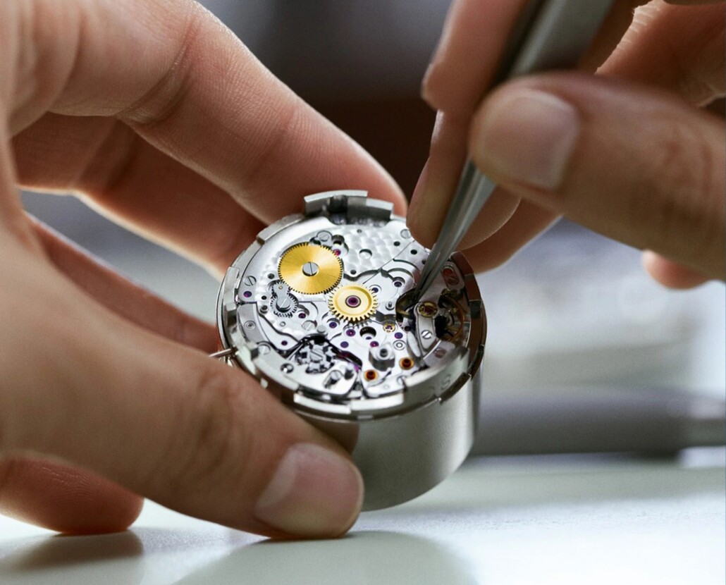 A horologist at work, adjusting various watch parts