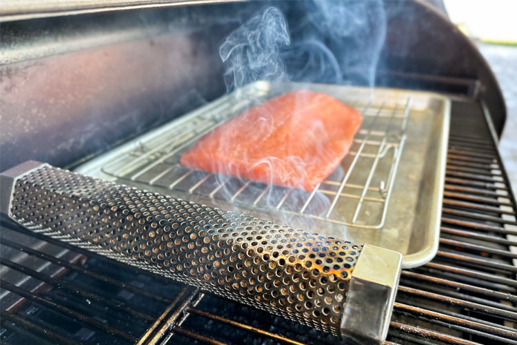 smoke tube in grill with smoke, salmon filet in background