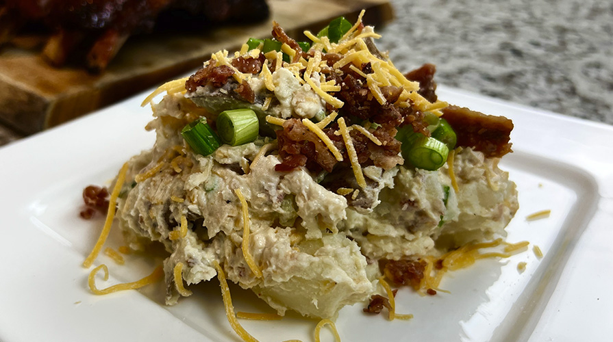 loaded baked potato salad next to bbq ribs