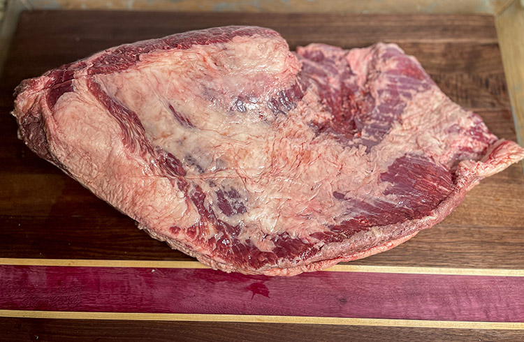 raw American Wagyu brisket on a wooden board