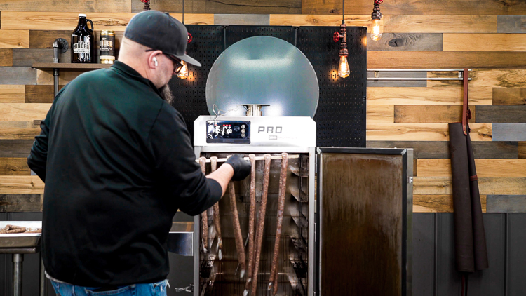 hanging snack sticks on rod in smoker