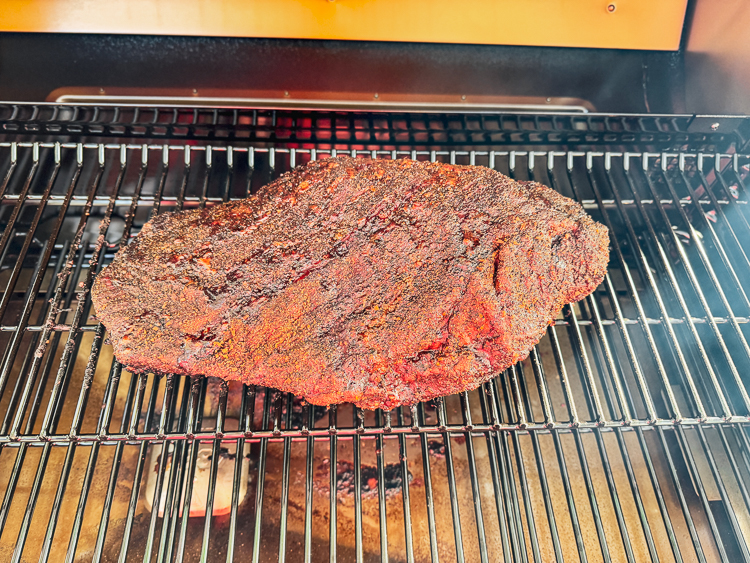 raw seasoned costco brisket on the smoker