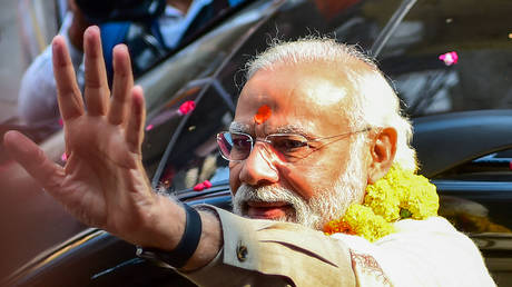 Indian Prime Minister Narendra Modi gestures as he arrives to inaugurate the Kashi Vishwanath Dham Corridor, in Varanasi on December 13, 2021.