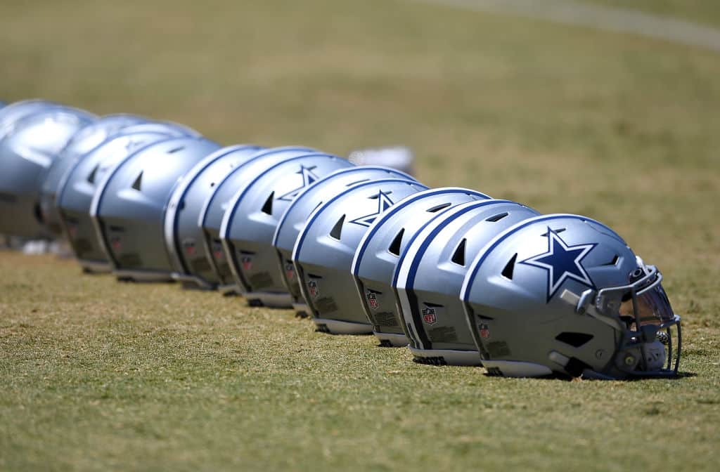 A detailed view of helmets of the Dallas Cowboys lined up on the field during training camp at River Ridge Complex on August 3, 2021 in Oxnard, California.