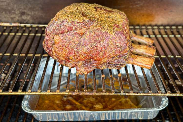 cooked prime rib in the smoker with foil tray underneath