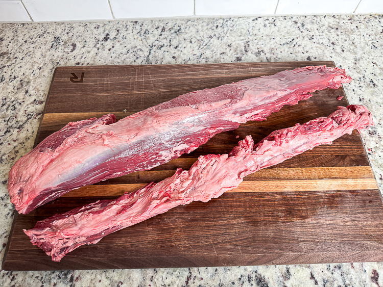 filet with the chain removed on a wooden chopping board