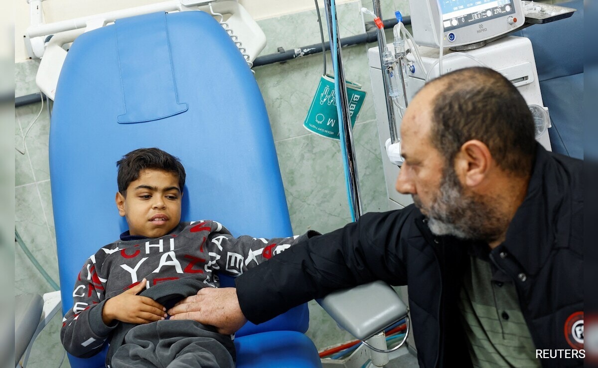 Palestinian boy Naseem Mohra is looked after by his neighbour Adel Haniyeh, as he undergoes kidney dialysis at a hospital in Rafah in the southern Gaza Strip.