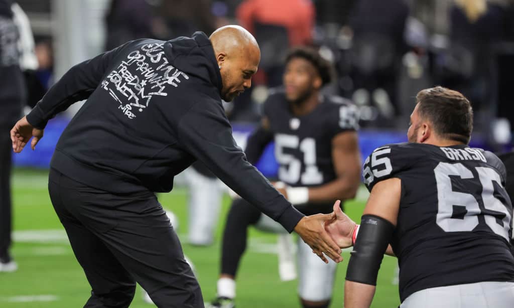 interim head coach Antonio Pierce of the Las Vegas Raiders greets center Hroniss Grasu #65 before their game against the Los Angeles Chargers at Allegiant Stadium on December 14, 2023 in Las Vegas, Nevada. The Raiders defeated the Chargers 63-21.