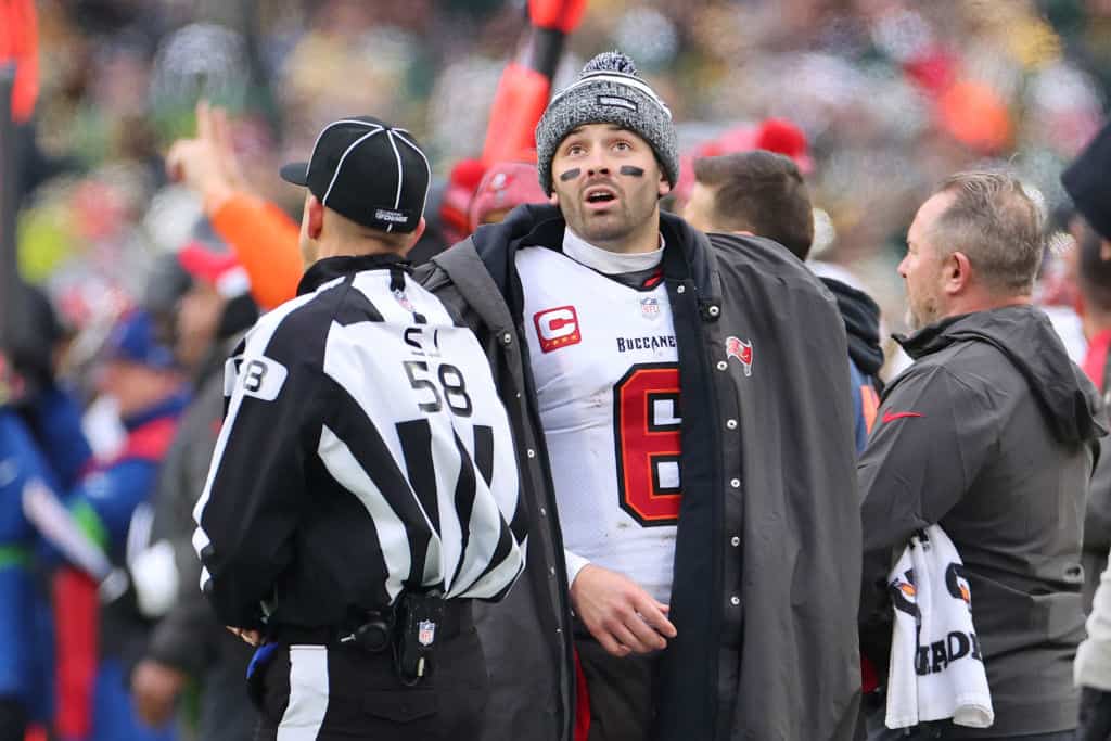 Baker Mayfield #6 of the Tampa Bay Buccaneers speaks with side judge Don Willard #58 during a game against the Green Bay Packers at Lambeau Field on December 17, 2023 in Green Bay, Wisconsin. The Buccaneers defeated the Packers 34-20.