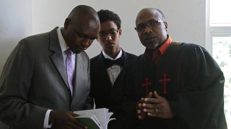 FILE PHOTO: Ugandan anti-gay preacher Pastor Martin Ssempa (R) speaks to anti-gay activists at the constitutional court in Kampala on July 30, 2014.