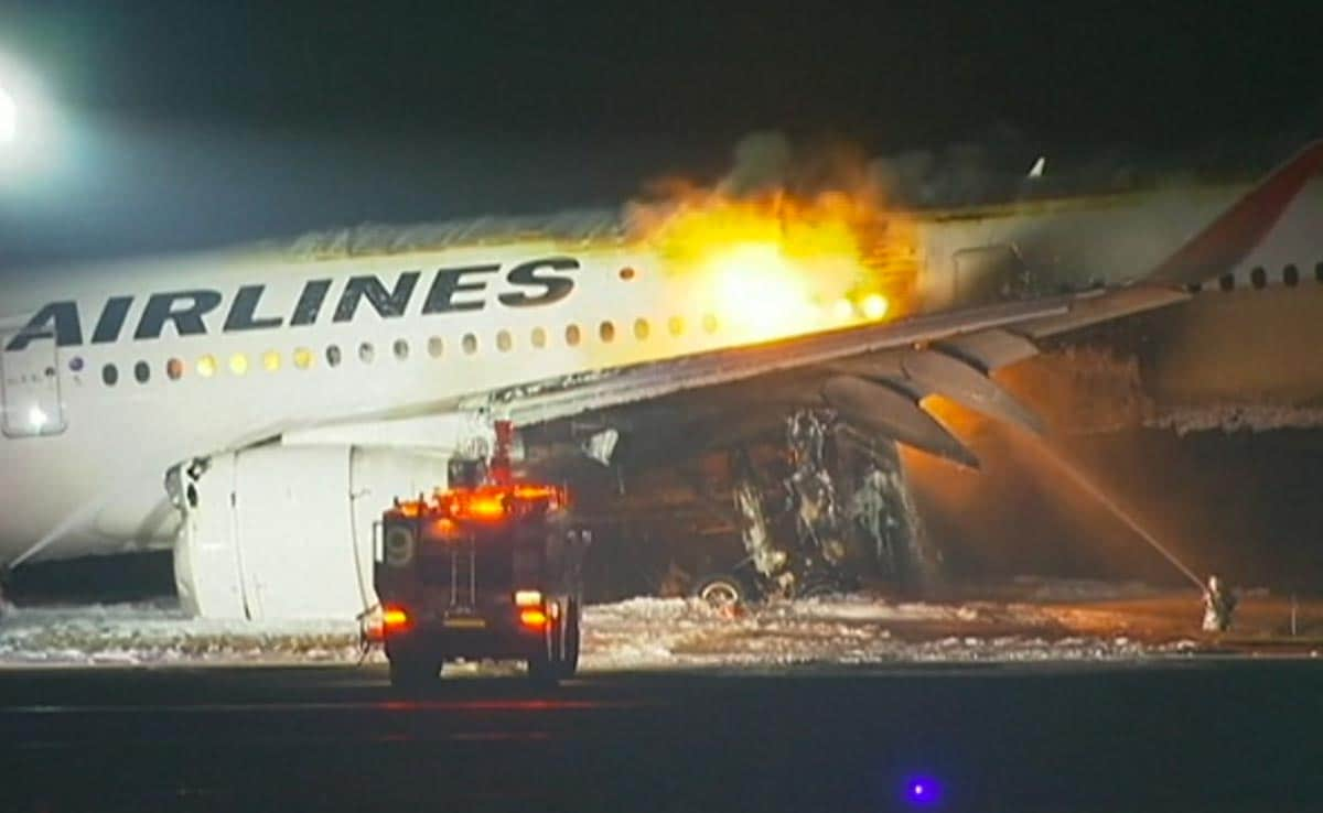 Rescue workers trying to douse the fire after a Japan Airlines airplane caught fire