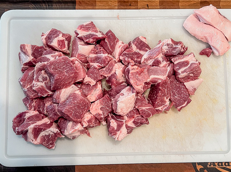 cubed up pork shoulder on white board