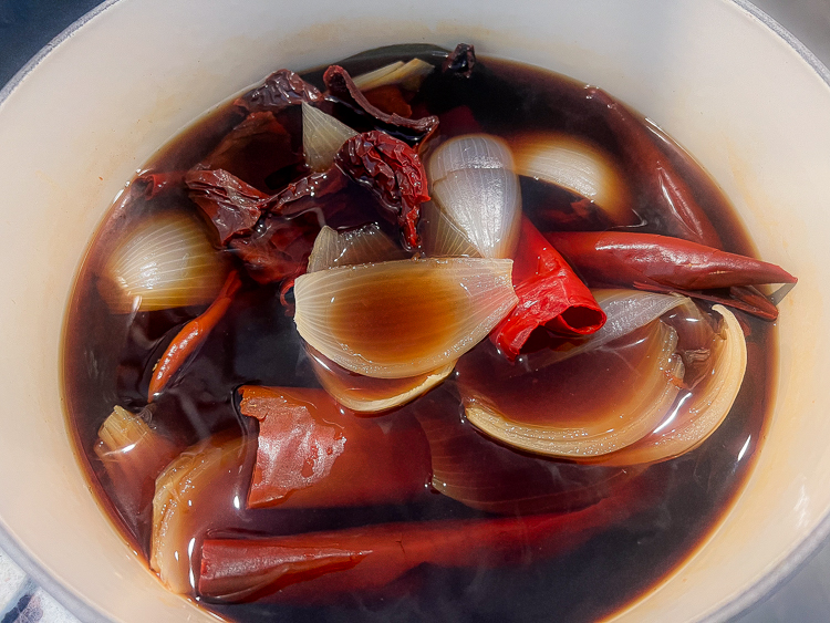 onions, bay, garlic and chilis in a pot of water