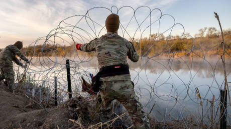 Texas National Guard soldiers install razor wire lie along the Rio Grande on January 10, 2024 in Eagle Pass, Texas.