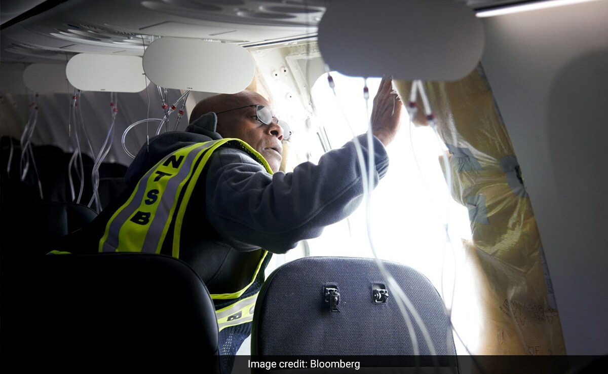 A National Transportation Safety Board investigator examines the fuselage plug area of the Alaska Airlines 737 Max 9. 