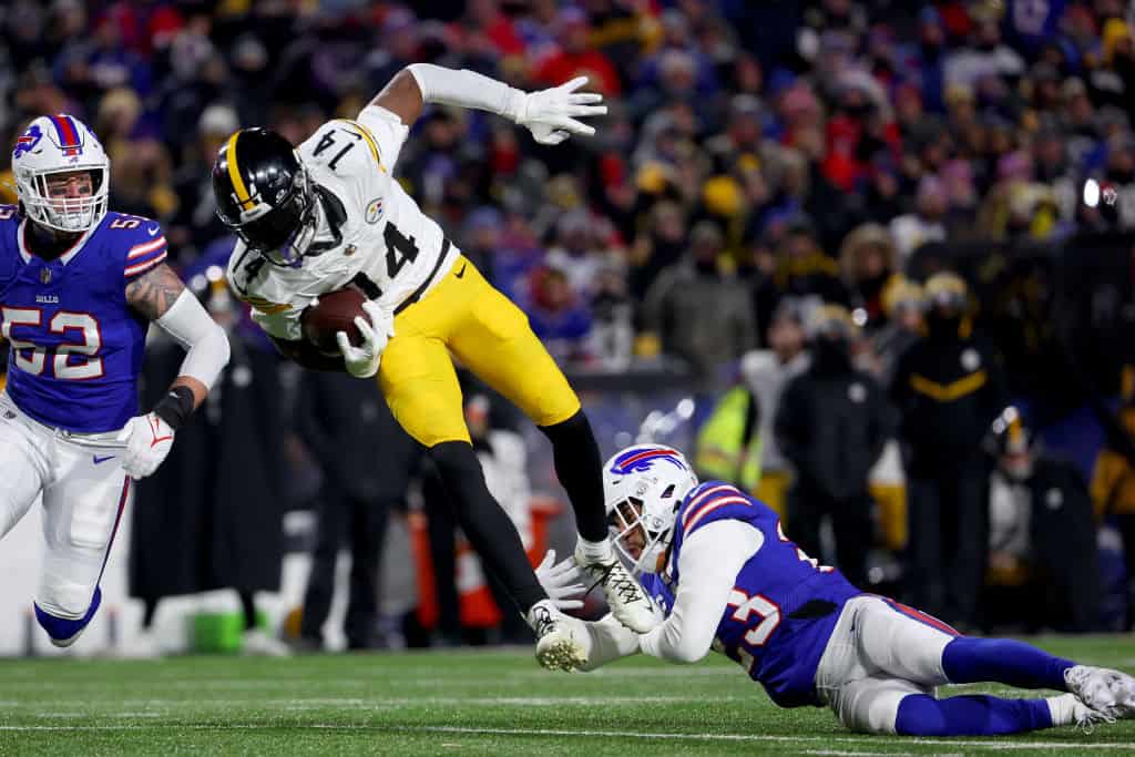 George Pickens #14 of the Pittsburgh Steelers catches a pass against Micah Hyde #23 of the Buffalo Bills during the third quarter at Highmark Stadium on January 15, 2024 in Orchard Park, New York.