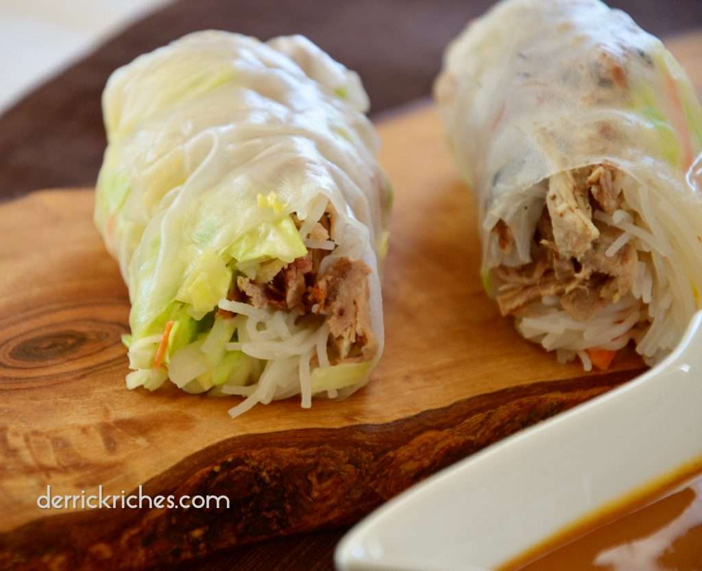 Fresh Pulled Pork Spring Rolls on a cutting board with sauce